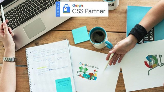 Flatlay eines Tisches mit Laptop, Unterlagen und Kaffeetasse. Zwei Kolleginnen sprechen über die Vorteile eines Google CSS-Partners.